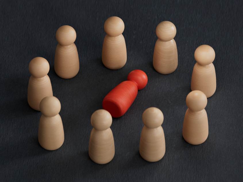 Block people surrounding differently colored block person - Hostile Work Enviorment